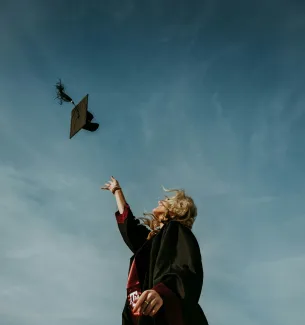 a woman flying a kite in a blue sky by Caleb Holden courtesy of Unsplash.