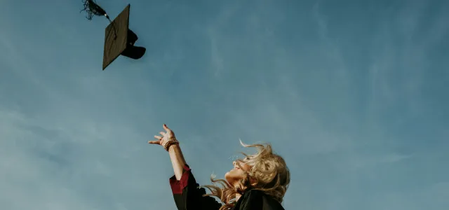 a woman flying a kite in a blue sky by Caleb Holden courtesy of Unsplash.